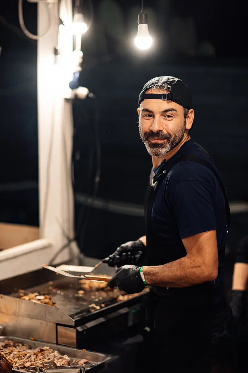 Cuoco sorridente alla piastra notte