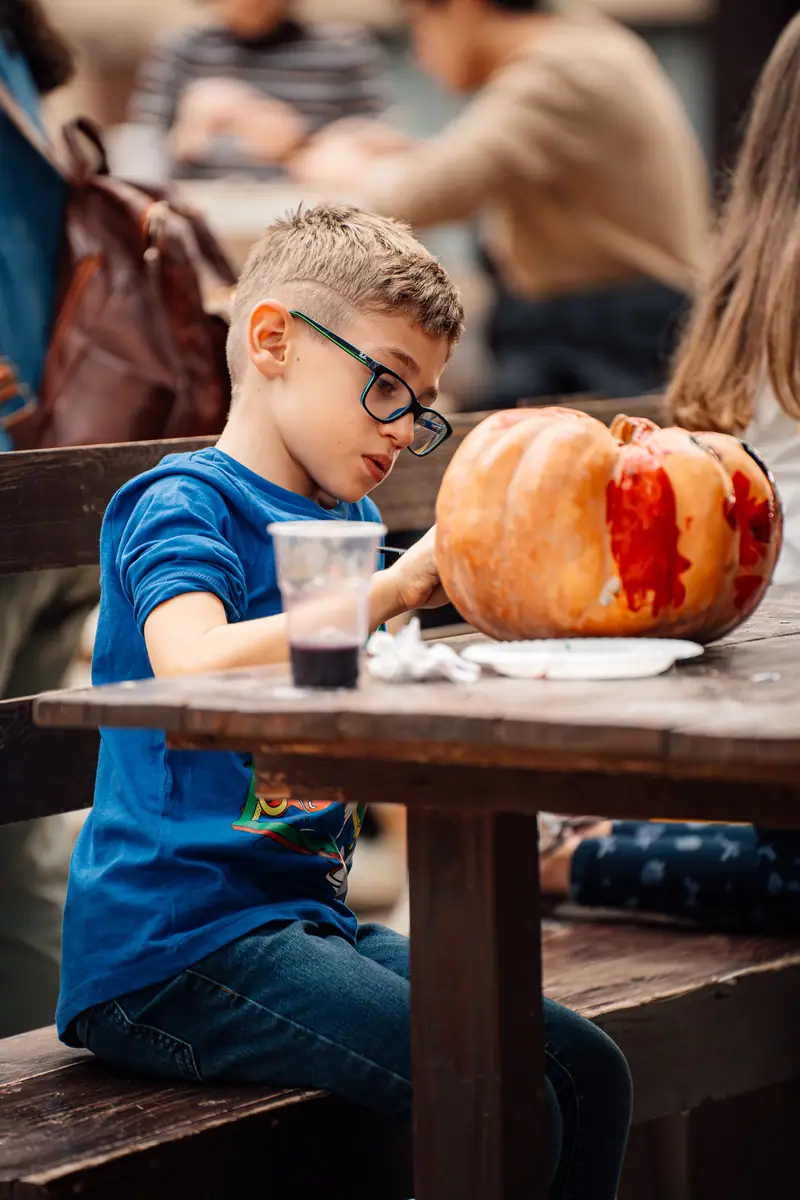 Bimbo con occhiali dipinge zucca
