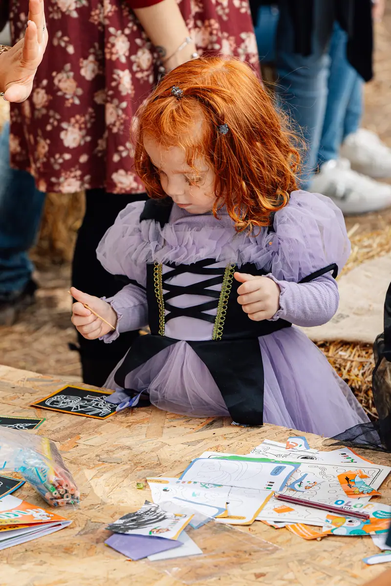 Bimba in costume con cartoncini creativi