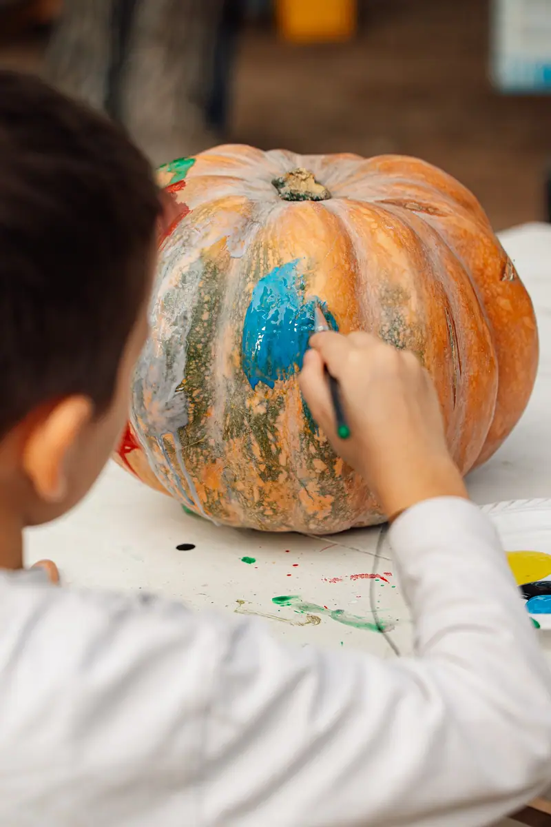 Bimbo dipinge zucca, vista da dietro