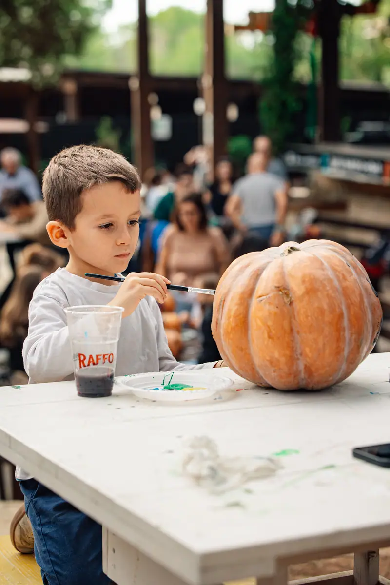 Bimbo dipinge zucca al tavolo