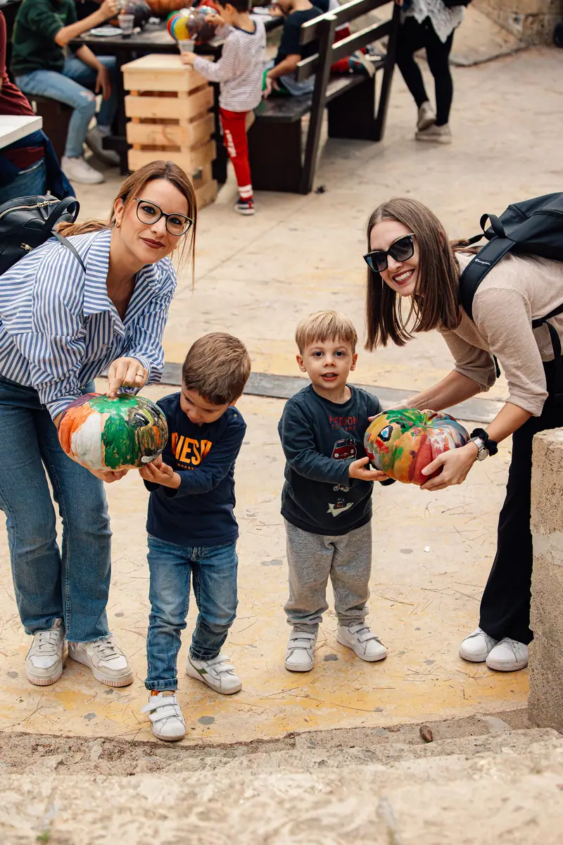 Mamme e bimbi con zucche dipinte