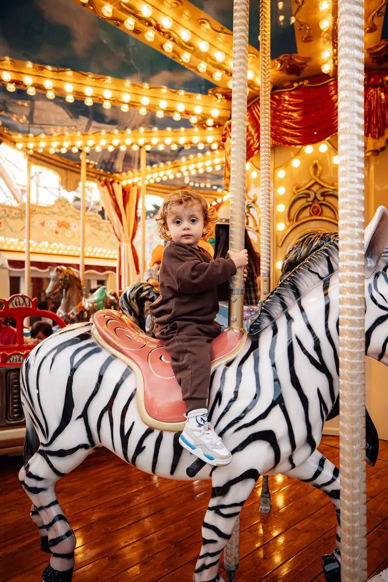 Bimbo sulla zebra della giostra