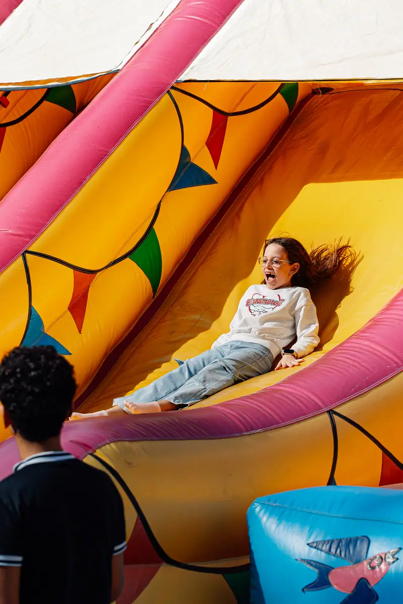 Bambina felice su scivolo gonfiabile